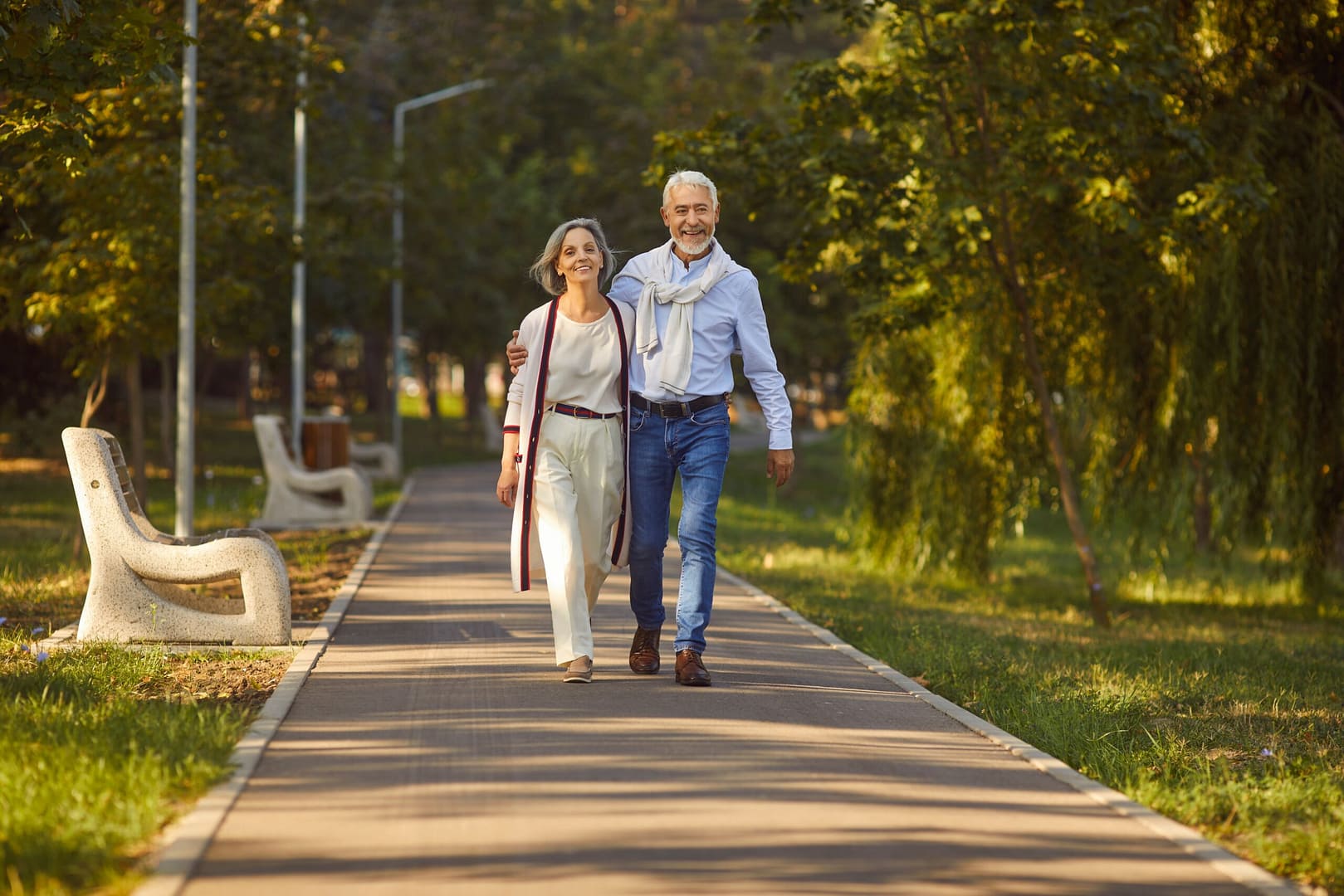Picture of an older couple walking through the park.
